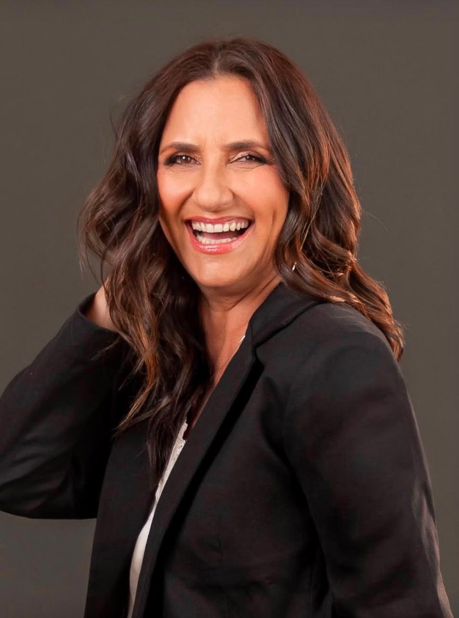 Jaqueline Santos sorrindo, de blazer preto